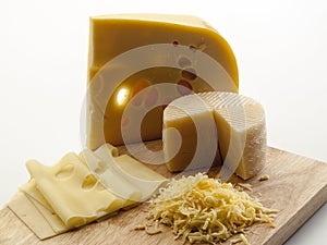 Cutting board with two cheeses, grated and sliced Ã¢â¬â¹Ã¢â¬â¹on it photo